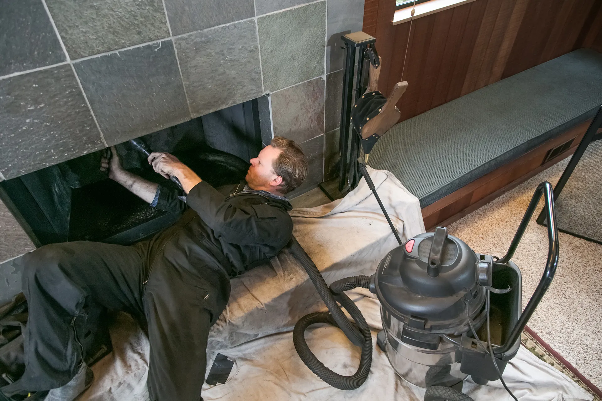 Chimney sweep technician working at a fireplace
